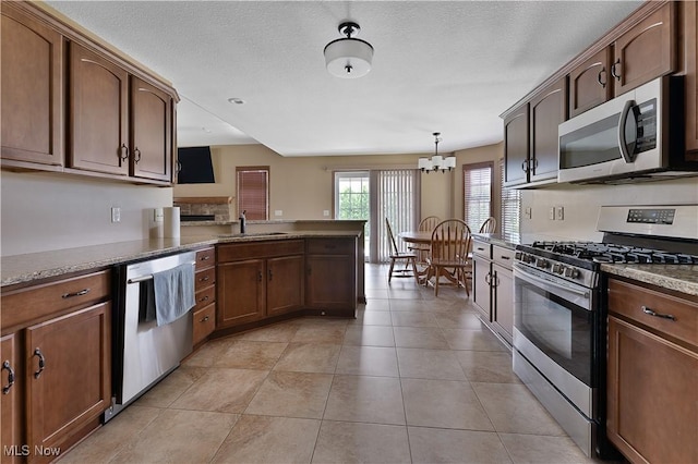4053 Thats Life Ln, Canfield, OH 44406 - kitchen with stainless steel appliances, a chandelier, a peninsula, light tile patterned floors, and decorative light fixtures
