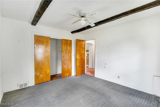 700 Alice St, East Palestine, OH 44413 - unfurnished bedroom with beam ceiling, arched walkways, carpet floors, ceiling fan, and a closet