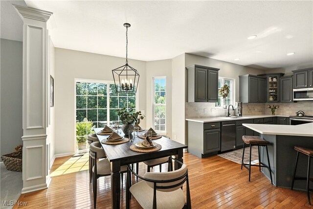 10421 Tolland Dr, Reminderville, OH 44202 - dining room with light wood-style flooring, a chandelier, decorative columns, and recessed lighting