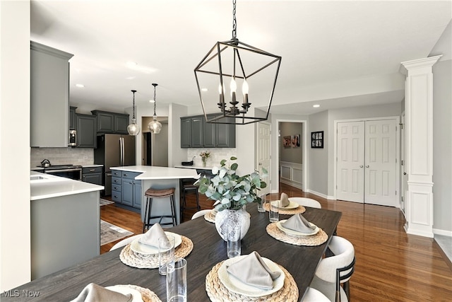 10421 Tolland Dr, Reminderville, OH 44202 - dining space featuring a chandelier, dark wood finished floors, recessed lighting, and ornate columns
