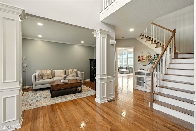 10421 Tolland Dr, Reminderville, OH 44202 - living area with decorative columns, hardwood / wood-style flooring, stairway, ornamental molding, and recessed lighting