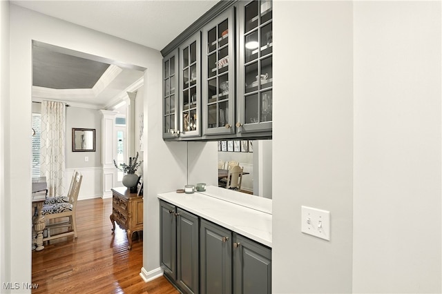 10421 Tolland Dr, Reminderville, OH 44202 - bar featuring dark wood-style floors, ornamental molding, a tray ceiling, decorative columns, and wainscoting