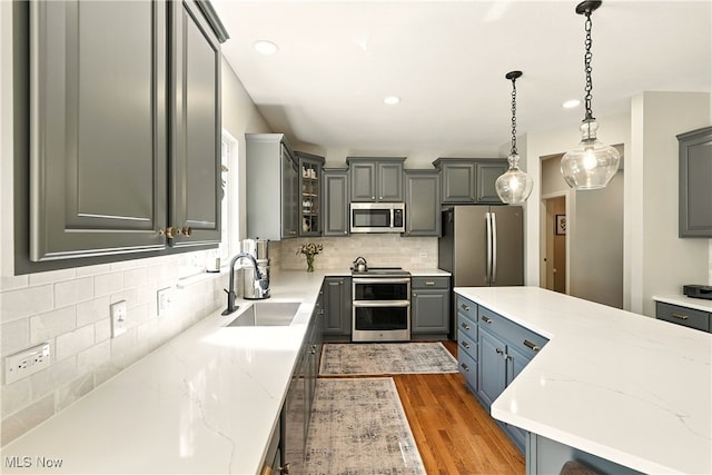 10421 Tolland Dr, Reminderville, OH 44202 - kitchen featuring appliances with stainless steel finishes, gray cabinets, decorative backsplash, wood finished floors, and recessed lighting