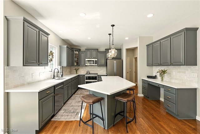 10421 Tolland Dr, Reminderville, OH 44202 - kitchen featuring stainless steel appliances, backsplash, a center island, a breakfast bar, and dark wood-style flooring