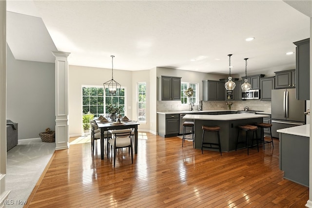 10421 Tolland Dr, Reminderville, OH 44202 - kitchen with stainless steel appliances, ornate columns, a center island, light countertops, and recessed lighting