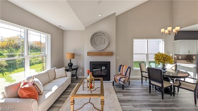 5007 Coventry Cir, Huron, OH 44839 - living room featuring a glass covered fireplace, a chandelier, wood finished floors, healthy amount of natural light, and high vaulted ceiling