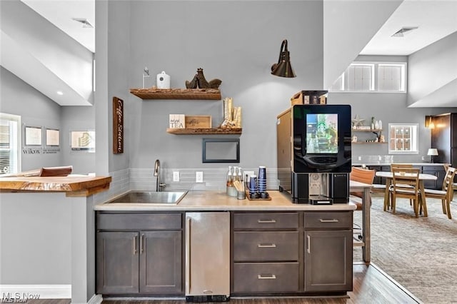 5007 Coventry Cir, Huron, OH 44839 - kitchen with fridge, healthy amount of natural light, open shelves, wood finished floors, and high vaulted ceiling