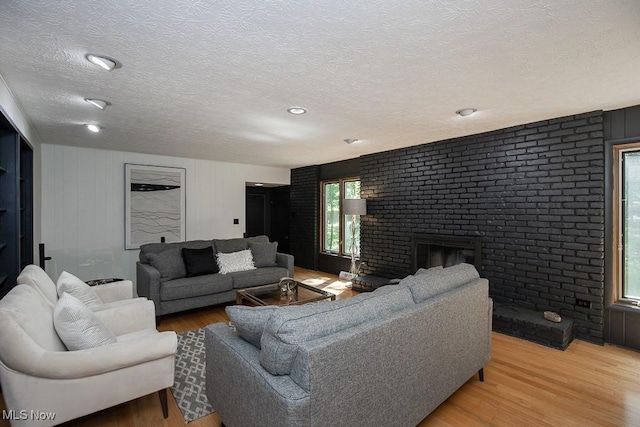 4280 Som Center Rd, Moreland Hills, OH 44022 - living room featuring light wood-style flooring, a textured ceiling, and a fireplace