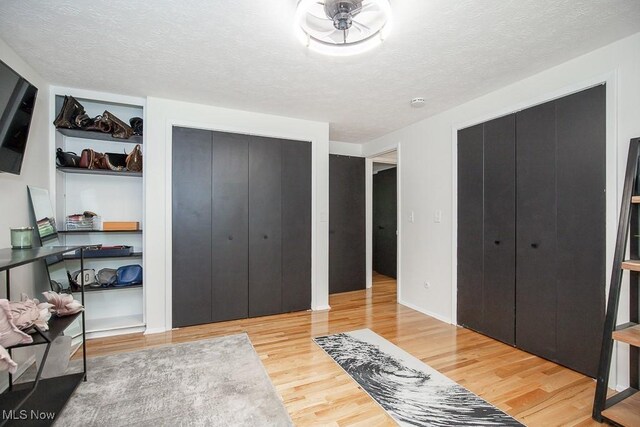 4280 Som Center Rd, Moreland Hills, OH 44022 - bedroom featuring wood finished floors, two closets, and a textured ceiling