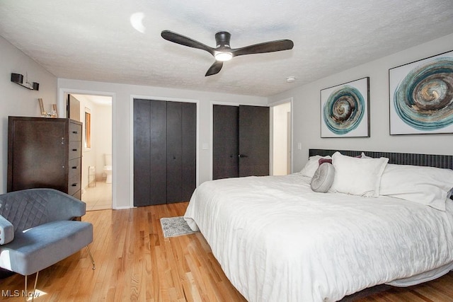 4280 Som Center Rd, Moreland Hills, OH 44022 - bedroom with light wood finished floors, multiple closets, ensuite bathroom, a ceiling fan, and a textured ceiling