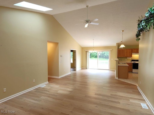 422 Dartmouth Trl, Sagamore Hills, OH 44067 - unfurnished living room featuring light wood finished floors, high vaulted ceiling, ceiling fan, a skylight, and a chandelier