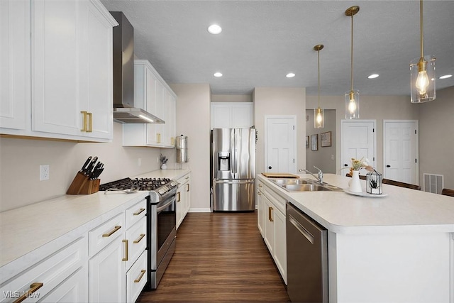 37282 Amber Way N, Ridgeville, OH 44039 - kitchen featuring stainless steel appliances, wall chimney exhaust hood, a center island with sink, dark wood-style floors, and white cabinetry
