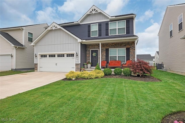 37282 Amber Way N, Ridgeville, OH 44039 - craftsman house featuring board and batten siding, a porch, stone siding, a front yard, and driveway