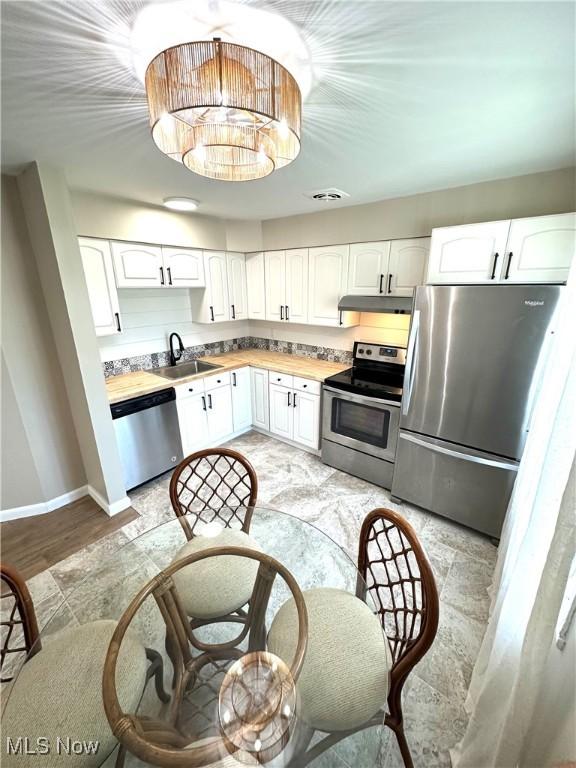 4235 Patricia Ave, Austintown, OH 44511 - kitchen with appliances with stainless steel finishes, white cabinets, and under cabinet range hood