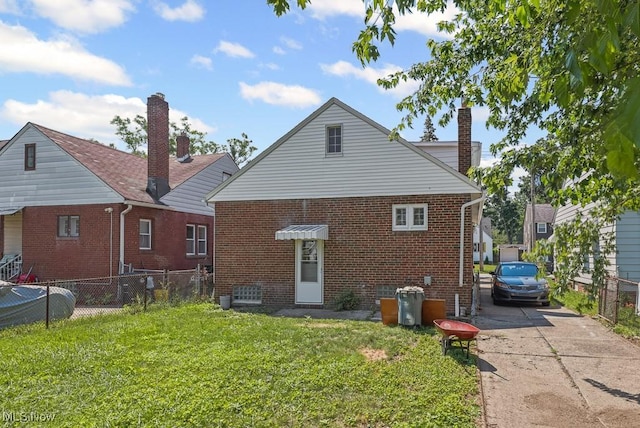 5902 Vandalia Ave, Cleveland, OH 44144 - rear view of house with brick siding, concrete driveway, and a chimney