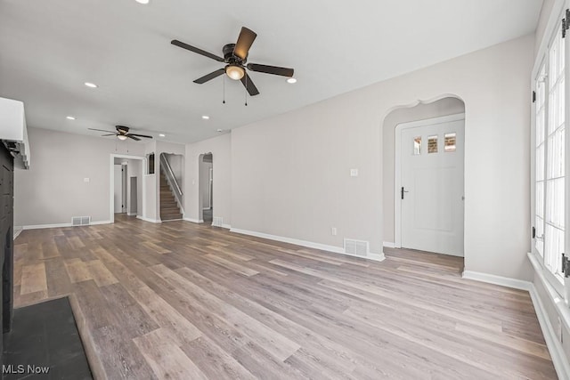 5902 Vandalia Ave, Cleveland, OH 44144 - unfurnished living room with arched walkways, recessed lighting, a ceiling fan, light wood-style flooring, and stairs