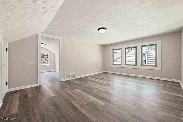 5902 Vandalia Ave, Cleveland, OH 44144 - empty room with a textured ceiling, dark wood-style flooring, and vaulted ceiling