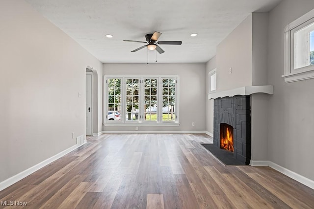 5902 Vandalia Ave, Cleveland, OH 44144 - unfurnished living room featuring a fireplace, ceiling fan, wood finished floors, recessed lighting, and arched walkways