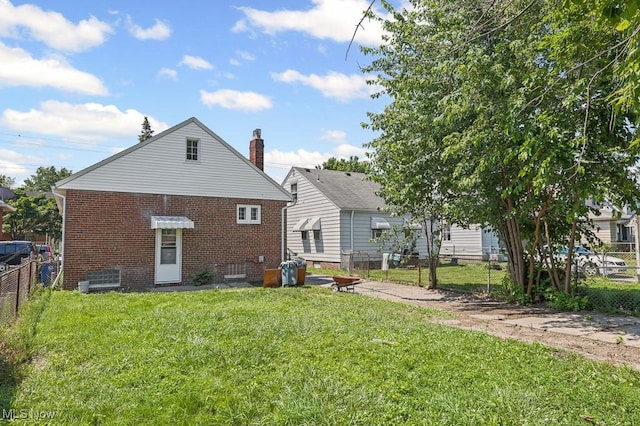5902 Vandalia Ave, Cleveland, OH 44144 - rear view of house with brick siding and an outdoor fire pit