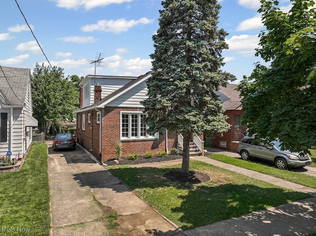 5902 Vandalia Ave, Cleveland, OH 44144 - obstructed view of property with brick siding, concrete driveway, and a front lawn