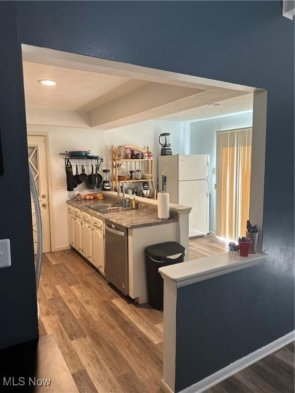 3123 S Duck Creek Rd, North Jackson, OH 44451 - kitchen featuring dishwasher, freestanding refrigerator, a peninsula, light wood-style floors, and white cabinetry