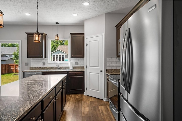 13176 Barrington Dr, Grafton, OH 44044 - kitchen with stainless steel appliances, dark wood-style flooring, a textured ceiling, decorative backsplash, and dark brown cabinets
