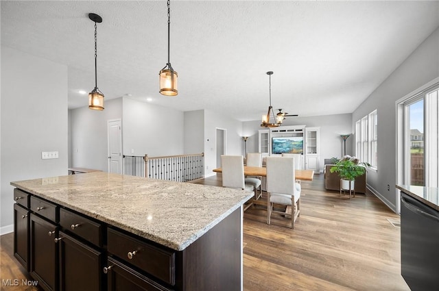 13176 Barrington Dr, Grafton, OH 44044 - kitchen featuring stainless steel dishwasher, open floor plan, wood finished floors, decorative light fixtures, and a chandelier