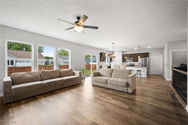 13176 Barrington Dr, Grafton, OH 44044 - living room featuring dark wood-type flooring, a textured ceiling, a ceiling fan, a chandelier, and recessed lighting