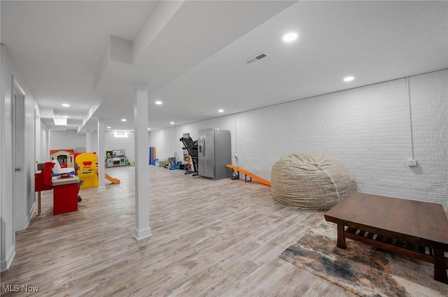 13176 Barrington Dr, Grafton, OH 44044 - workout area with light wood-style flooring, recessed lighting, and brick wall