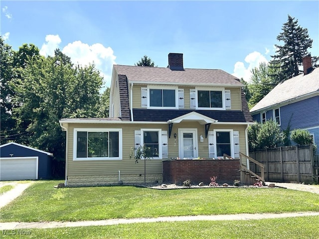 1820 E 47th St, Ashtabula, OH 44004 - view of front of property featuring a garage, a chimney, an outbuilding, and a shingled roof