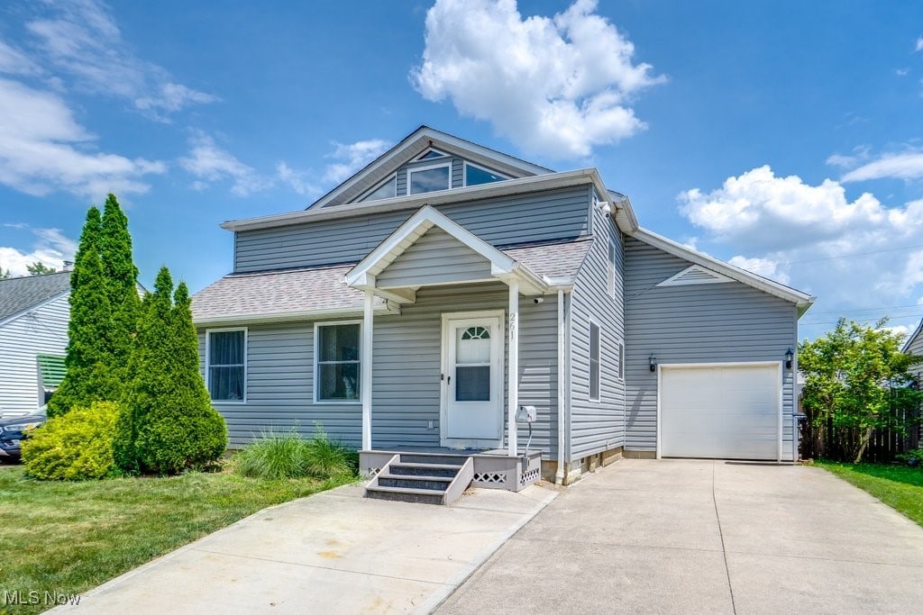 261 Hawthorne St, Elyria, OH 44035 - view of front facade with concrete driveway, a garage, and roof with shingles