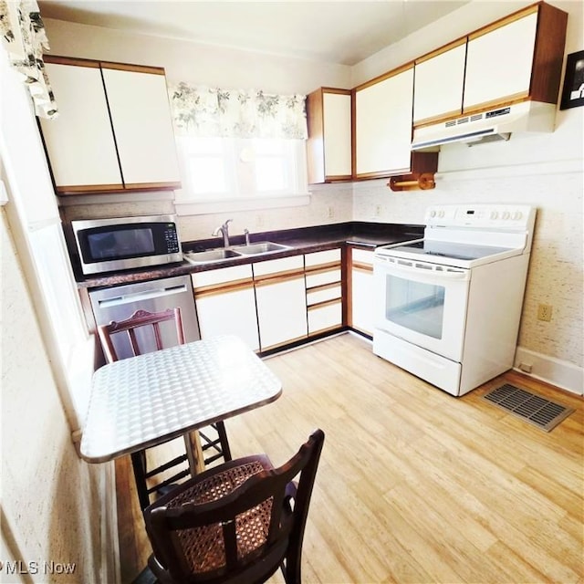 3303 Hemlock St, Parkersburg, WV 26101 - kitchen featuring stainless steel appliances, under cabinet range hood, white cabinets, and light wood-type flooring