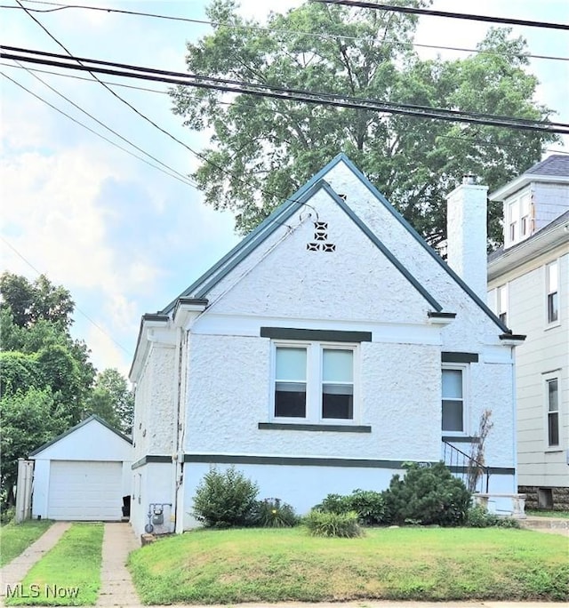 3303 Hemlock St, Parkersburg, WV 26101 - view of front of house with an outbuilding, stucco siding, driveway, and a front lawn