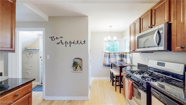 3622 Northcliffe Rd, University Heights, OH 44118 - kitchen with stainless steel appliances, light wood-style flooring, dark stone counters, and a chandelier