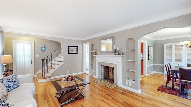 3622 Northcliffe Rd, University Heights, OH 44118 - living area featuring arched walkways, wood finished floors, stairway, built in features, and a fireplace with flush hearth