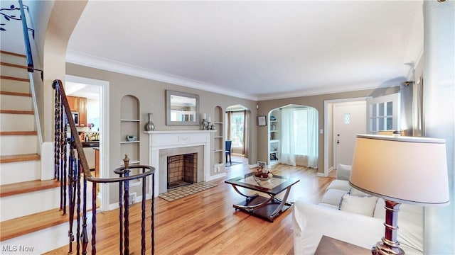 3622 Northcliffe Rd, University Heights, OH 44118 - living room with wood finished floors, ornamental molding, arched walkways, stairway, and a fireplace with flush hearth