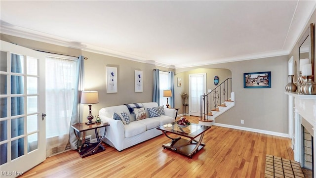 3622 Northcliffe Rd, University Heights, OH 44118 - living room with light wood-type flooring, healthy amount of natural light, a fireplace with flush hearth, crown molding, and stairs