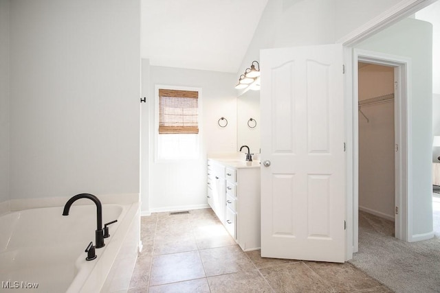 31008 Logan Ct, Westlake, OH 44145 - full bathroom with vanity, a bath, a walk in closet, lofted ceiling, and tile patterned flooring