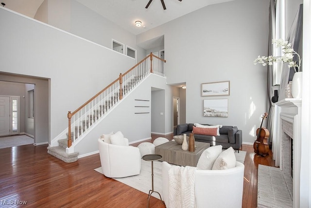 31008 Logan Ct, Westlake, OH 44145 - living room with stairs, high vaulted ceiling, wood finished floors, a ceiling fan, and a brick fireplace