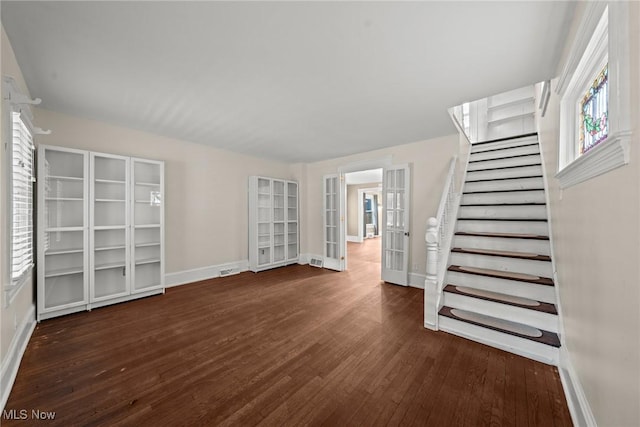 2905 Jay Ave, Cleveland, OH 44113 - unfurnished living room featuring wood finished floors, plenty of natural light, french doors, and stairs