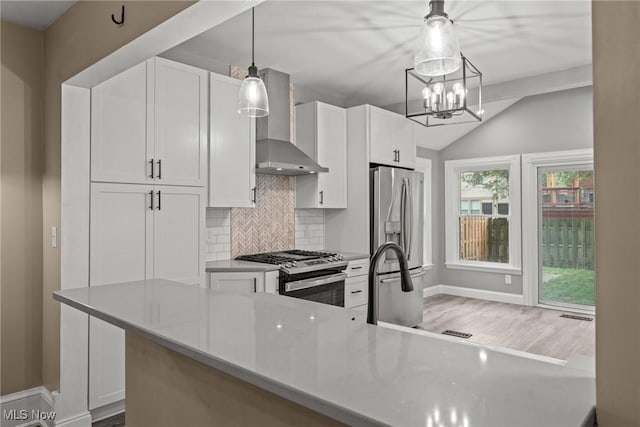 2905 Jay Ave, Cleveland, OH 44113 - kitchen with wall chimney range hood, appliances with stainless steel finishes, vaulted ceiling, white cabinets, and backsplash