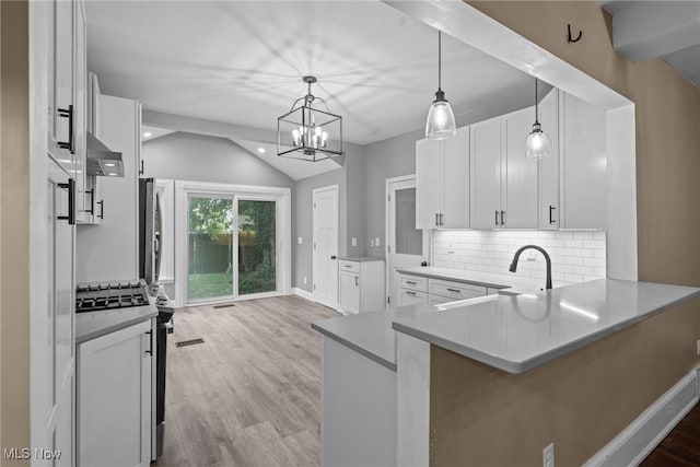 2905 Jay Ave, Cleveland, OH 44113 - kitchen featuring light wood finished floors, under cabinet range hood, lofted ceiling, white cabinets, and decorative backsplash