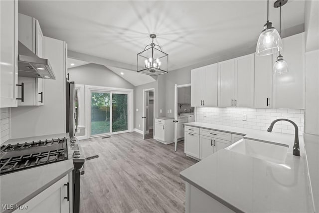 2905 Jay Ave, Cleveland, OH 44113 - kitchen featuring exhaust hood, stainless steel range with gas stovetop, vaulted ceiling, tasteful backsplash, and white cabinets