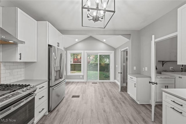 2905 Jay Ave, Cleveland, OH 44113 - kitchen featuring stainless steel appliances, wall chimney range hood, light countertops, light wood-style floors, and lofted ceiling