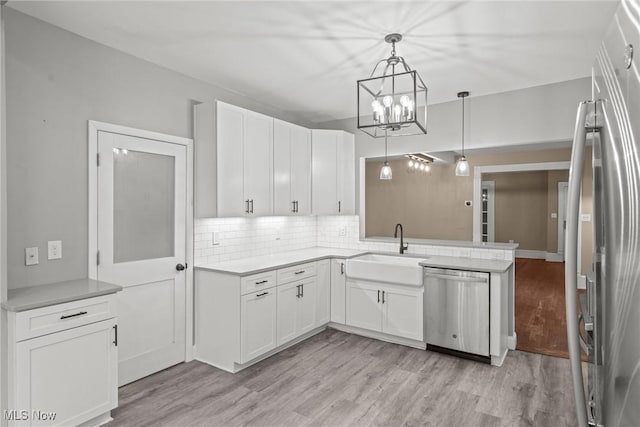 2905 Jay Ave, Cleveland, OH 44113 - kitchen with appliances with stainless steel finishes, light wood-style floors, tasteful backsplash, and white cabinetry