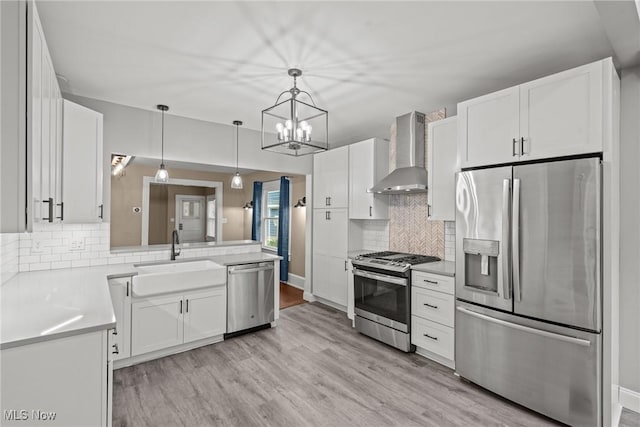 2905 Jay Ave, Cleveland, OH 44113 - kitchen featuring stainless steel appliances, wall chimney exhaust hood, backsplash, and light wood-style floors