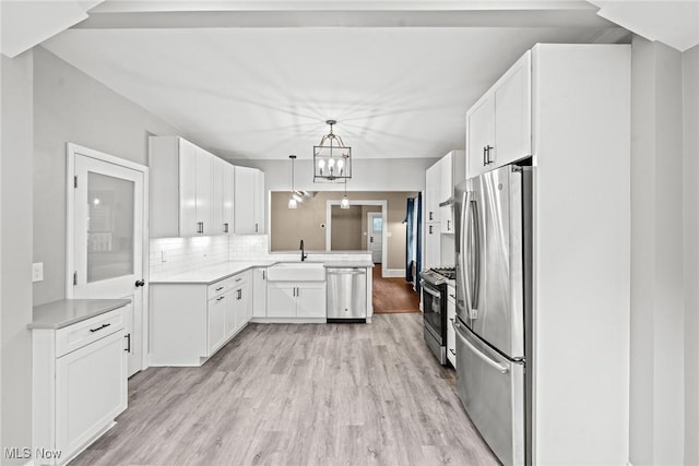 2905 Jay Ave, Cleveland, OH 44113 - kitchen with appliances with stainless steel finishes, light wood-type flooring, a peninsula, tasteful backsplash, and light countertops