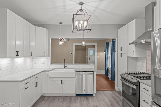 2905 Jay Ave, Cleveland, OH 44113 - kitchen with stainless steel appliances, wall chimney exhaust hood, light countertops, and white cabinetry