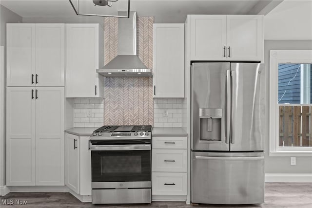 2905 Jay Ave, Cleveland, OH 44113 - kitchen featuring appliances with stainless steel finishes, wall chimney range hood, white cabinetry, and tasteful backsplash