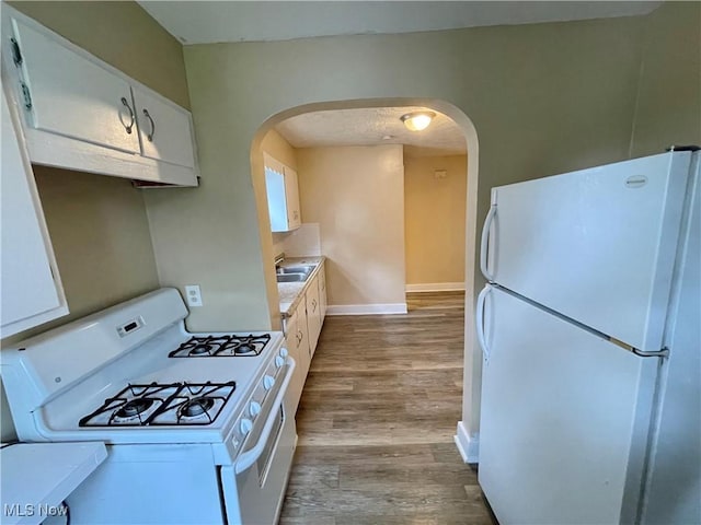 918 Silvercrest Ave, Akron, OH 44314 - kitchen with white appliances, arched walkways, wood finished floors, and white cabinets